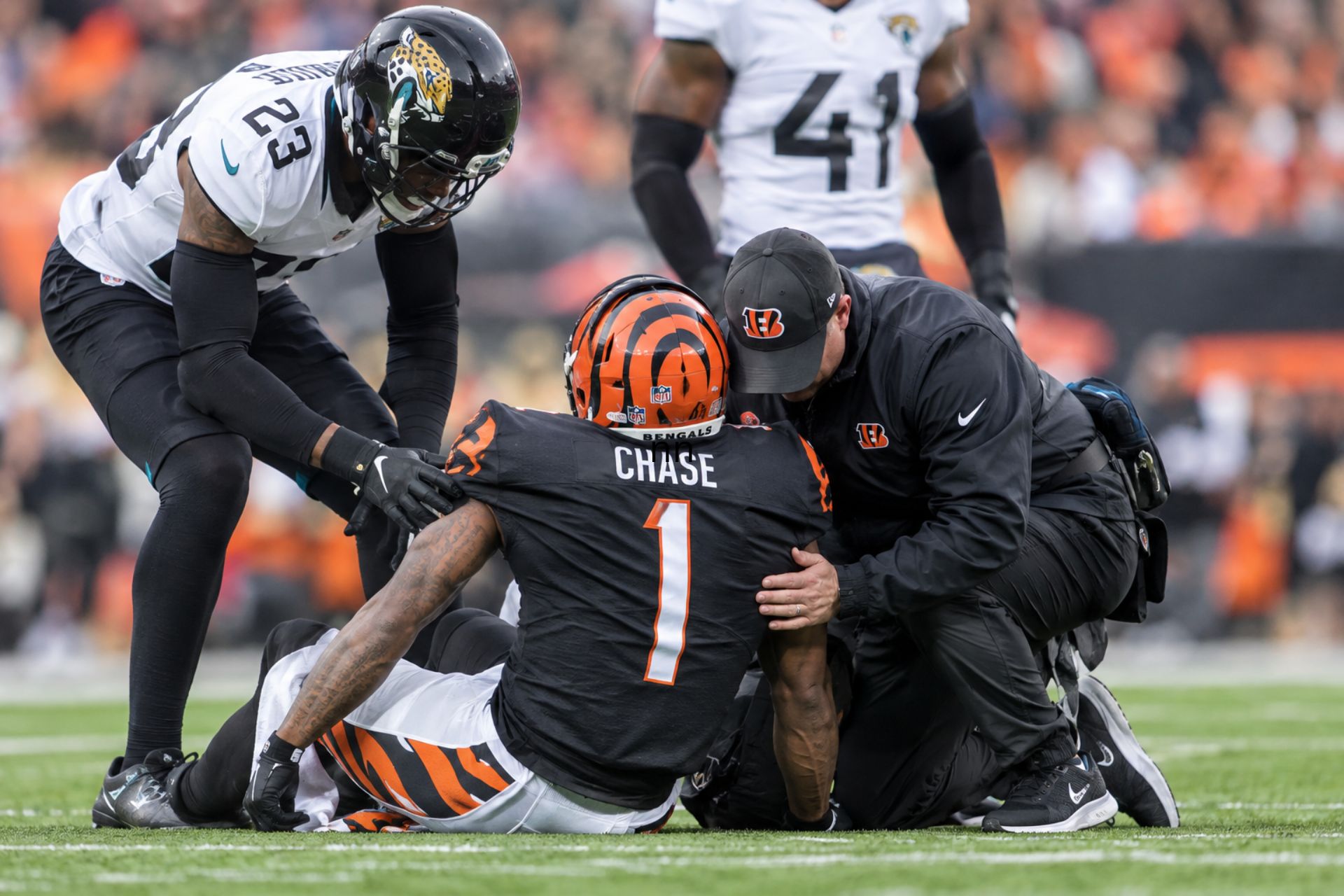 An AI-generated photo of Cincinnati Bengals player Ja'Marr Chase sits on the field while being attended to by medical staff during a game against the Jacksonville Jaguars.