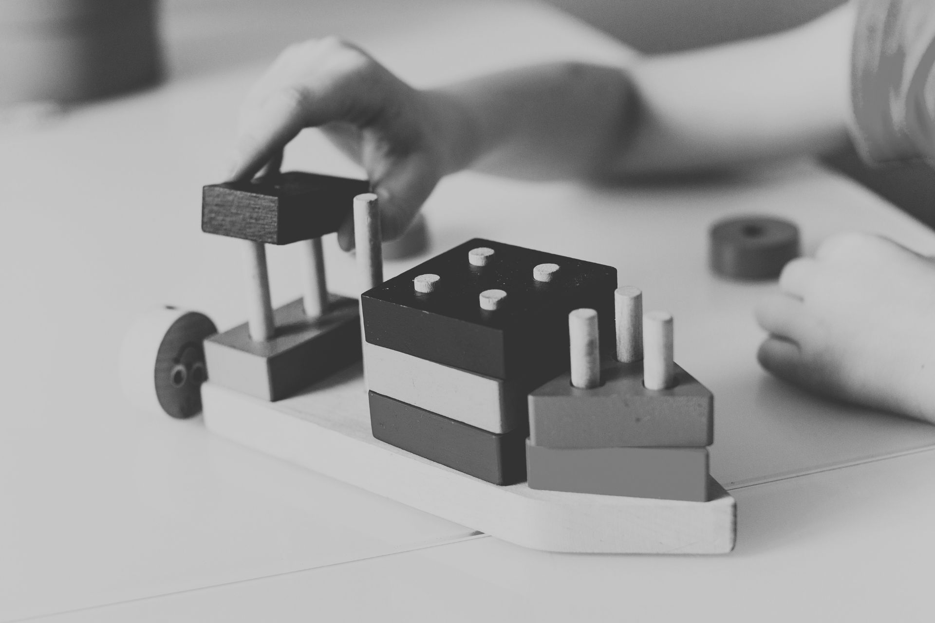 Black and white photo of a child's hands playing with building blocks.